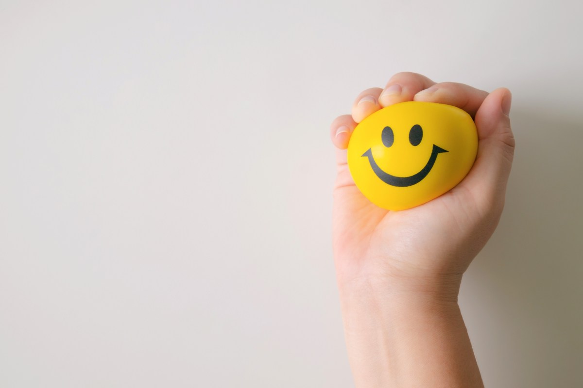 Hand squeezing yellow stress ball